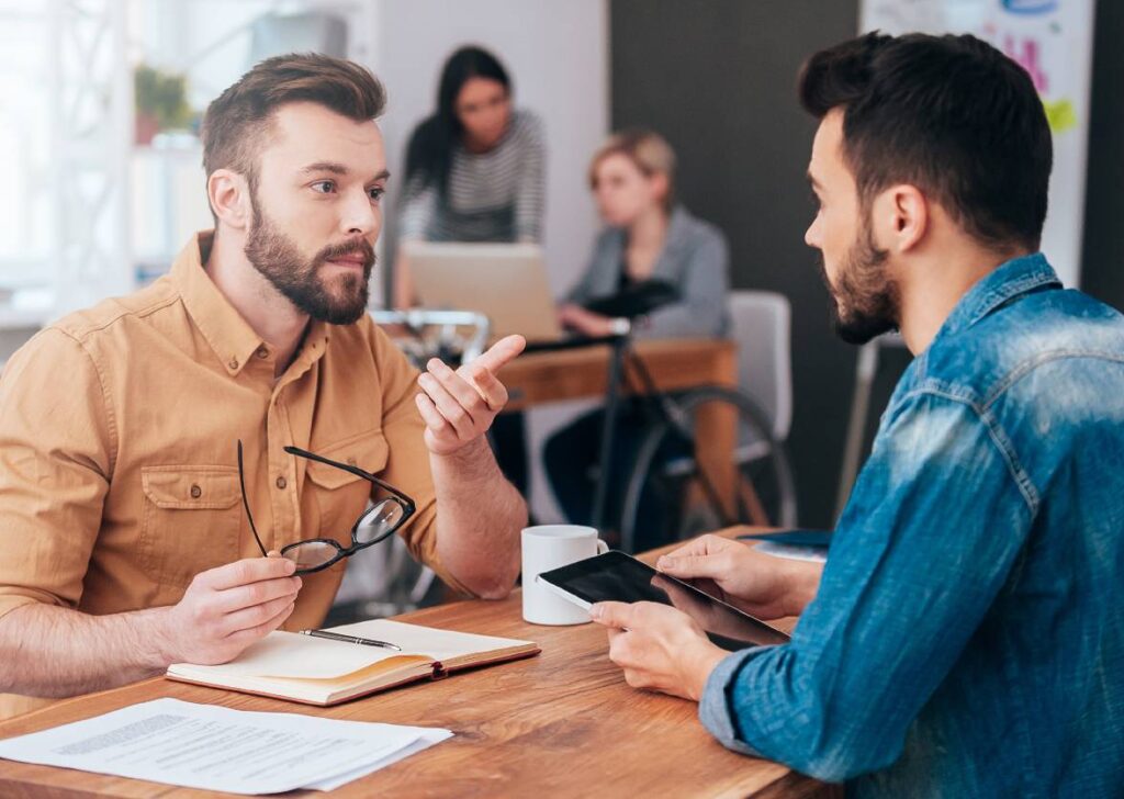 Zwei Mitarbeiter im Gespräch – Transportpartner für Automotive, Maschinenbau und Lebensmittelindustrie